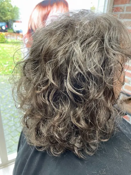 Deze dame heeft een mooie volle bos krullen door de permanent die Leonie bij deze dame heeft gezet. De krullen zijn wat grover gezet zodat de krullen mooi natuurlijk overkomen.